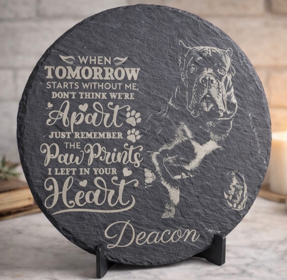 Round slate pet memorial engraved with a photo of a dog named Deacon and a paw prints poem